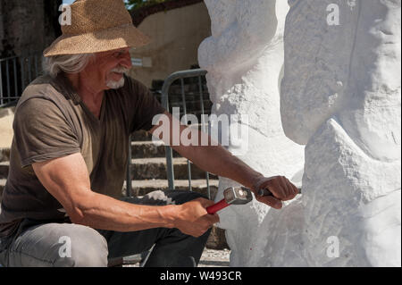 Senior Bildhauer arbeiten im Freien auf seinem Marmor Skulptur in seinem Workshop mit Hammer und Meißel Stockfoto