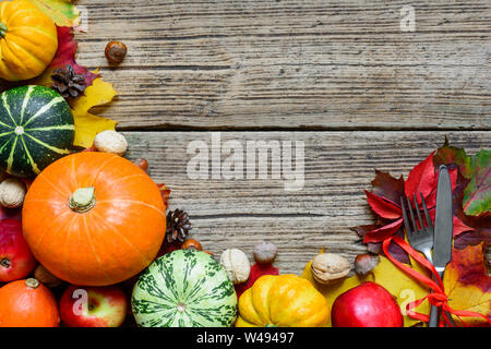 Thanksgiving Tisch mit Geernteten Kürbisse, Äpfel, Nüsse und Blätter im Herbst. Thanksgiving essen Hintergrund. Ansicht von oben mit der Kopie Raum Stockfoto