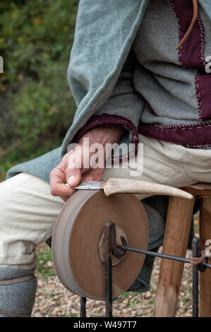 Die messerschleifer arbeitet in einem kleinen mittelalterlichen Dorf Stockfoto