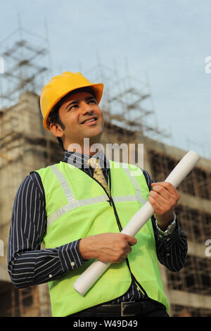 Architekt mit Bauplan auf einer Baustelle Stockfoto