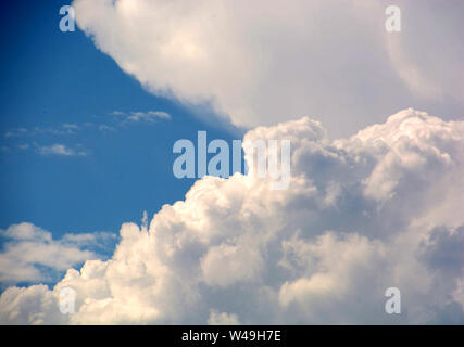 Gigantische Wolken am blauen Himmel, große cumulus Wolken vor blauem azurblauen Himmel kurz vor einem Sturm Stockfoto
