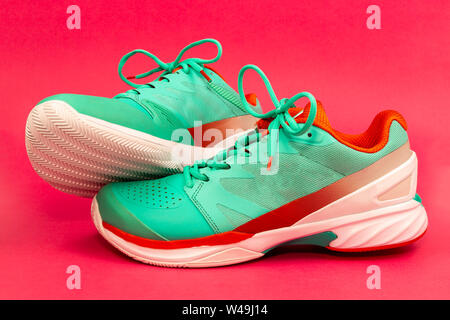 Rot, hellblau, weiß, Paar neue Tennisschuhe im Studio auf einem violetten Hintergrund isoliert. Stockfoto