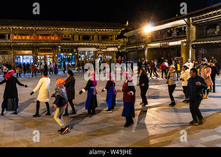 Shangri La, China - 28. Februar 2019: die Menschen tanzen traditionelle tibetische Tänze im Kreis in der Nacht im Herzen der Altstadt in Shangri La Stockfoto
