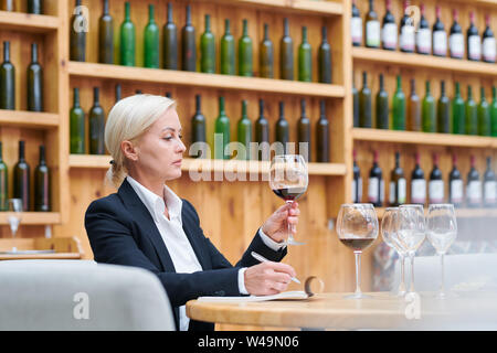 Professionelle in Weingut Prüfung Farbe und Qualität von Rotwein Stockfoto