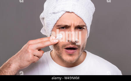 Schöner Mann, Creme auf seine Wangen wie Warrior Stockfoto