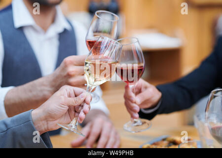 Drei Menschen klirren mit weingläser von verschiedenen Arten von Wein Stockfoto