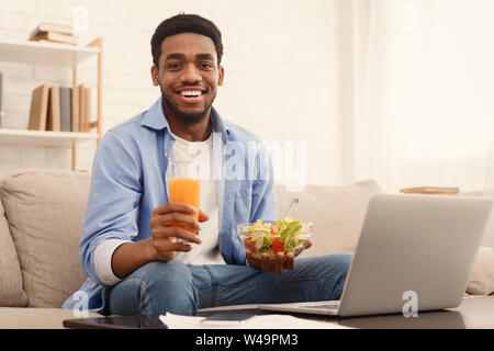 Fröhliche african-american man gesunde Mittagessen zu Hause Stockfoto