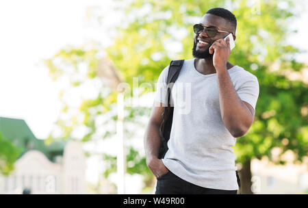 Stilvolle afrikanischer Mann sprechen am Telefon im Stadtpark, Stockfoto