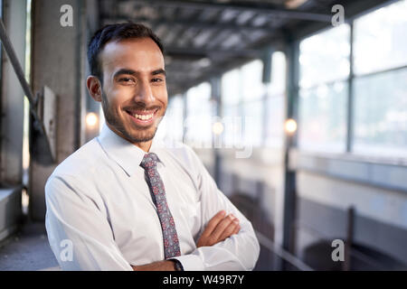 Indischer Geschäftsmann selbstbewusst lächelnd mit stadtbild Hintergrund Stockfoto