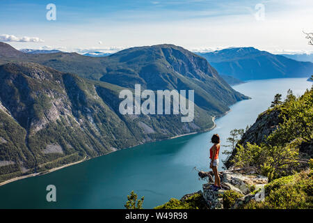 Frau Reisende genießen Sie den malerischen Blick auf die norwegische Fjord bei einer Wanderung im Sommer Stockfoto