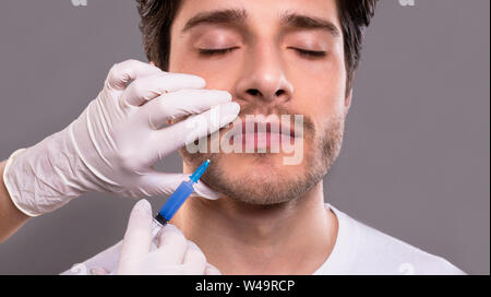 Männliche Patienten, die mit Botulinumtoxin Injektion in die Lippen Stockfoto