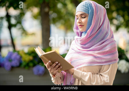 Junge muslimische Frauen mit offenem Buch lesen Geschichten oder Roman Stockfoto