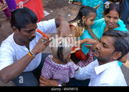 Wie pro Hindu, ein Junge bekommt seinen ersten Haarschnitt nach einem Besuch bei der Familie für einen Hindu Tempel, Mumbai, Indien Stockfoto