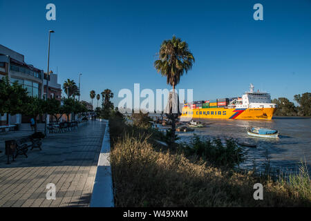 Durchgang von einem Frachtschiff aus Sevilla port gewichen und navigieren Guadalquivir Fluss bis zum Meer. Coria del Rio, Andalusien, Juli 2019 Stockfoto