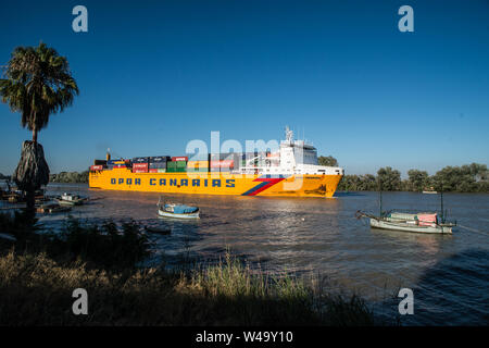 Durchgang von einem Frachtschiff aus Sevilla port gewichen und navigieren Guadalquivir Fluss bis zum Meer. Coria del Rio, Andalusien, Juli 2019 Stockfoto