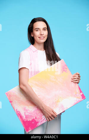 Glückliche junge brünette Frau mit Artwork Stockfoto