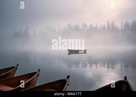 Boote auf dem Bergsee in geheimnisvollen Nebel. Strbske Pleso in der hohen Tatra, Slowakei. Stockfoto