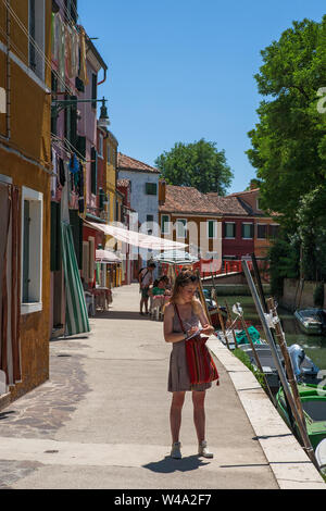 Mädchen mit einer Hinweis-Pad, Fondamenta di Terranova, Burano, Lagune von Venedig, Venetien, Italien Stockfoto