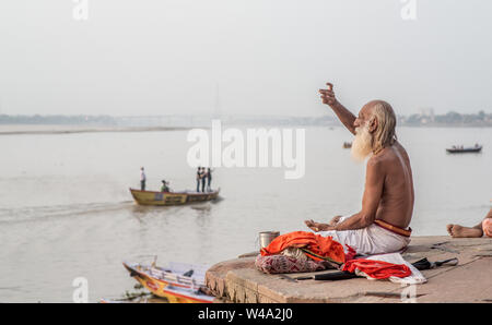 Ein Mann der hinduistischen Ritualen am Morgen in der heiligen Stadt am Ganges. Stockfoto