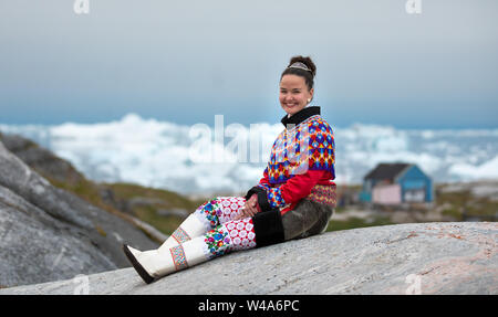 Junge inuit Frau in traditioneller Kleidung für Fotos in einem kleinen Dorf Greenlandish posieren. Stockfoto