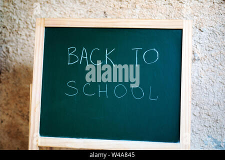 Schwarze Schule Schwarzes Brett auf dem Hintergrund der Wand mit der Inschrift zurück die Schule Stockfoto