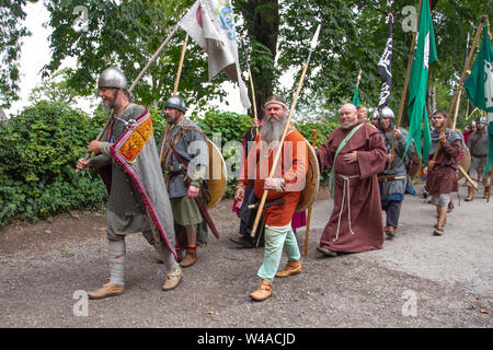 Wikingerzeit, Kleidung Kostüme & Waffen bei Heysham, Lancashire. Juli 2019. In der Morecambe Bay fliegen Kampfflaggen, während sich 70 historische Krieger auf einem Medieval Living History Encampment versammeln, um Waffen aus der Ära zu demonstrieren und auf dem Dorfgrün zu kämpfen. Die Götter IDIn, Thor und Frey wurden zusammen mit anderen Wikinger-Mythologien gefeiert. Stockfoto