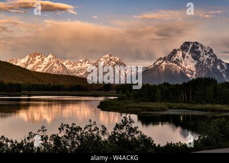 Mount Moran und die Grand Teton Berge auf dem Snake River bei Oxbow Bend in der Dämmerung mit der aufgehenden Sonne auf Wolken im Grand Teton National Park in Moran, Wyoming spiegelt wider. Stockfoto