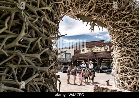 Jackson Polizei montiert Patrouille Offiziere stop mit Touristen durch die Elch Geweih Arch im George Washington Memorial Park gesehen, wie der Stadtplatz in Jackson Hole, Wyoming bekannt zu chatten. Vier Bögen der Marktplatz sind ausschließlich von der lokalen Elchengeweihen gebaut. Jeder Bogen wird von einem Stahlgerüst unterstützt und von Hand mit mehr als 2.000 Geweih jeden gebaut. Die Bögen sind meist durch Reibung und Schwerkraft gehalten und müssen über alle 50 Jahre wieder aufgebaut werden. Stockfoto