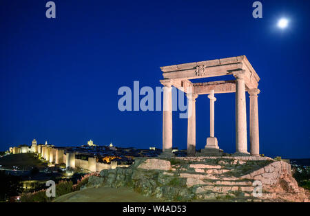 Der Mond über dem, mit Flutlicht steigende, Stadtmauer von Avila und die Cuatro Postes Denkmal, Avila, Spanien Stockfoto