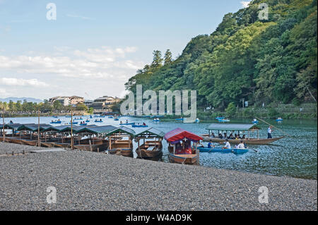 Boote auf dem Fluss Katsura über dem Mond Crossing Bridge, (Togetsukyo) im Hintergrund, Arashiyama, Japan Stockfoto