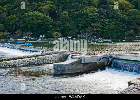 Kleine Boote oberhalb der Wehr, (im Vordergrund) über die katsura Fluß, nur über dem Mond Crossing Bridge (Togetsukyo), Arashiyama, Japan. Stockfoto