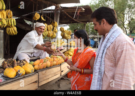 Pärchen kauft Mango an einem Marktstand Stockfoto