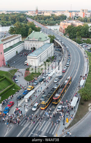 Schlangen von Autos Form als mehr als hundert Menschen verlassen Straßenbahnen und überqueren Sie die Straße an der Stare Miasto Straßenbahnhaltestelle in der Nähe von Castle Square in der Warschauer Altstadt. Stockfoto