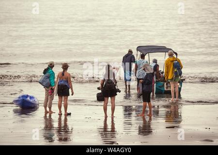 Einsteigen in ein Boot am Strand Stockfoto