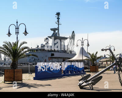 Varna, Bulgarien, 20. Juli 2019. Großes Kriegsschiff vertäut an der Pier im Hafen. Liegeplatz Territorium durch Zaun aus dem öffentlichen Teil eines Port getrennt. Stockfoto
