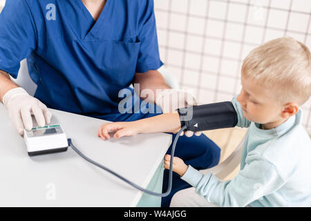 Arzt Blutdruck messen eines kleinen Jungen. Diagnose, Gesundheitswesen, ärztliche Betreuung. Arzt Kinderarzt Konzept Stockfoto