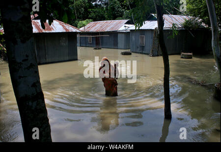 Tangail, Bangladesch. 21. Juli, 2019. Eine Frau, die ein Kind Spaziergänge in einer Flut betroffenen Bereich nach schweren Monsunregen an eine Flut betroffenen Bereich in Tangail. Über millionen Menschen durch Überschwemmungen durch den Monsun Regen und ausufernden Fluss im Norden, Nordosten und hügeligen Regionen in Bangladesch ausgelöst haben. Bild: Sultan Mahmud Mukut/SOPA Images/ZUMA Draht/Alamy leben Nachrichten Stockfoto