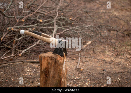 Zwei Achsen in einem Stich zum Spalten von Brennholz im Hof eines Landhauses Stockfoto