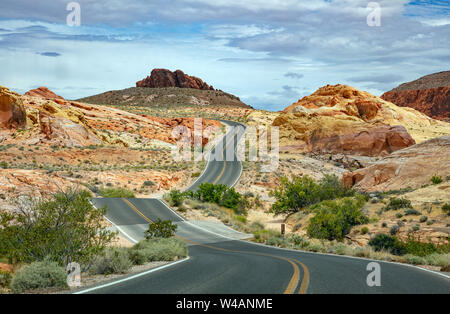 Tal des Feuers highway Nevada, USA. Leere kurvenreiche Straße, vorbei an der amerikanischen Wüste und Tal Red Rocks, Blau bewölkter Himmel Hintergrund Stockfoto