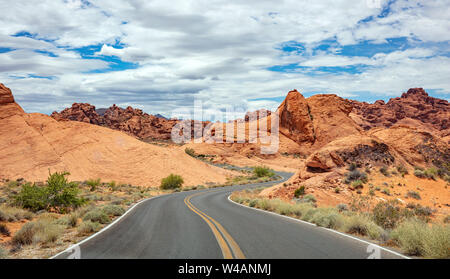 Tal des Feuers highway Nevada, USA. Leere kurvenreiche Straße, vorbei an der amerikanischen Wüste und Tal Red Rocks, Blau bewölkter Himmel Hintergrund Stockfoto