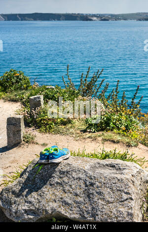 Ein paar New Balance Trainer links auf einen Felsen auf den Towan Kopf Landspitze in Newquay in Cornwall. Stockfoto