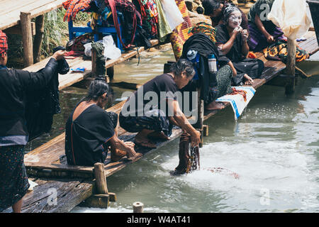 Indein, Myanmar - März 2019: burmesische Frauen aus PaO dragon Menschen Stamm Waschen im Fluss zum Inle See. Stockfoto