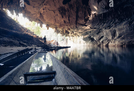 Menschliche Silhouette steht innerhalb Wasserhöhle mit einer Fackel in der Hand in Konglor, Laos. Stockfoto