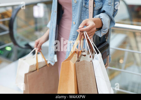 Junge Frau mit Papier Einkaufstüten in der Hand beim Shoppen in neuen großen Mall Stockfoto