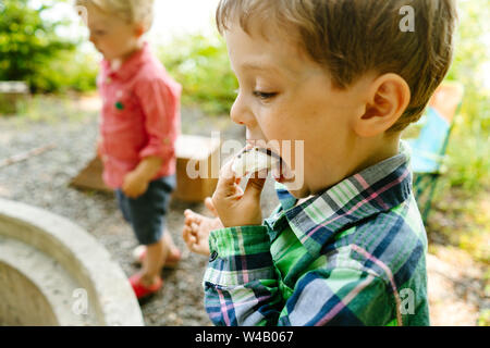 Closeup Seitenansicht eines Jungen essen ein Marshmallow smore Stockfoto