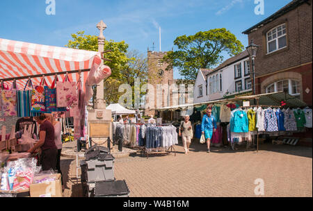Mann und Frau gehen zwischen den Ständen umliegenden Kriegerdenkmal am Wochenmarkt auf dem Marktplatz in Poulton le Fylde Lancashire England Großbritannien Stockfoto
