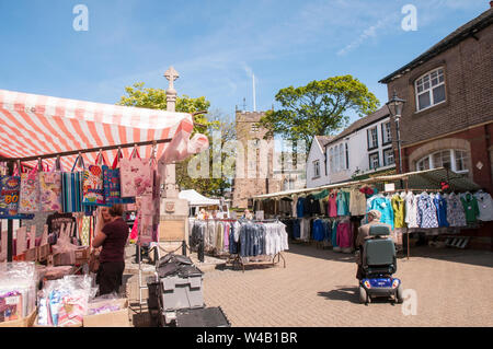 Mann auf Mobilität scooter an Verkaufsständen in der Umgebung War Memorial in wöchentlichen Markt auf dem Marktplatz in Poulton le Fylde Lancashire England Großbritannien Stockfoto