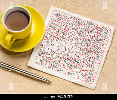 Wolke von positive Worte - Handschrift auf eine weiße Serviette mit einer Tasse Kaffee Stockfoto