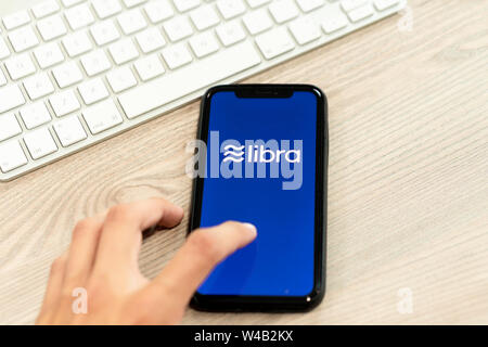 12 Juli 2019, Ljubljana Slowenien - Hand berühren Smartphone mit Waage Logo auf. Facebook Neue globale cryptocurrency für Transaktionen Stockfoto