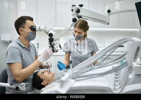 Die hübsche Frau, die Zähne Behandlung in der Zahnarztpraxis Stockfoto